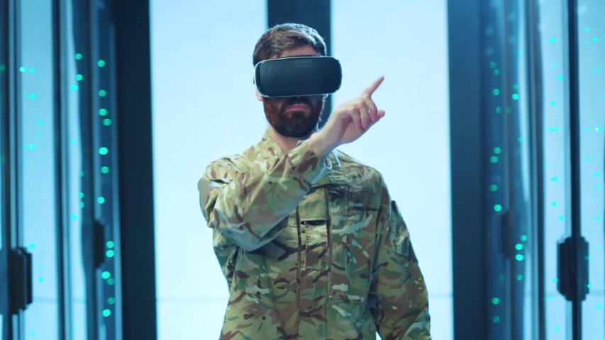 Military man IT technician wearing VR glasses interacting with virtual 3D interface networking wirelessly on server racks inside database cabinet. Data center modern technology. - Powered by Shutterstock - Get 15% off with code: PIKWIZARD15