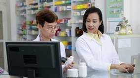 asian women Pharmacist checking and scanning barcode data on computer in pharmacy store Thailand 4k video footage 