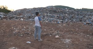 Boy Standing In Front Of Garbage Pile, Video In 4K
