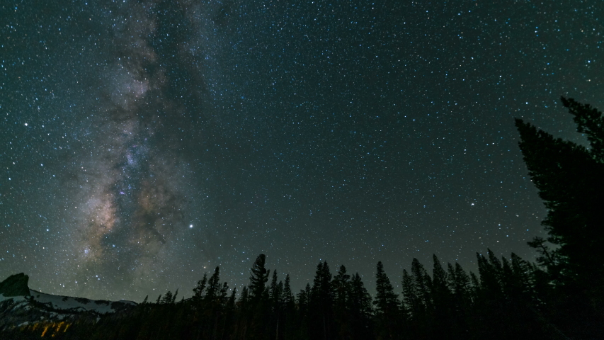 Astro timelapse of Milky Way galaxy over alpine trees at Mammoth Lakes in Sierra Nevada Mountains, California 