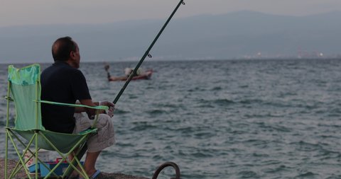 
man and fishing boat fishing at sunset