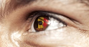 man with brown eyes in close up, the flag of Belgium in iris with wind motion. video concept