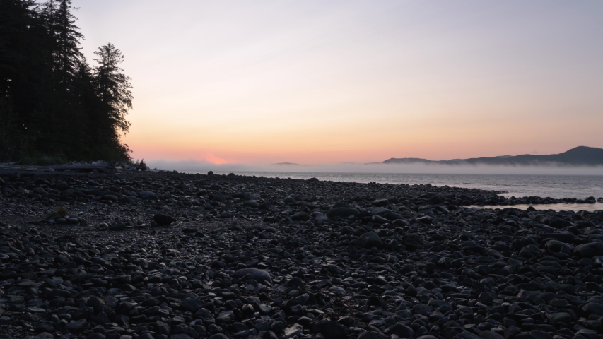 Wide, slow motion, sunset on a rocky beach, Vancouver Island, British Columbia Royalty-Free Stock Footage #1042829566