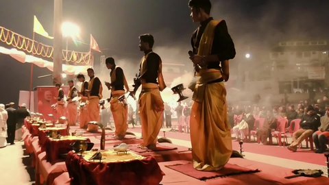 Varanasi, India, January 22, 2019: Young Hindu priests perform traditional Ganga aarti ceremony rituals with fire before sunrise at the Ganges river bank at Varanasi, India.