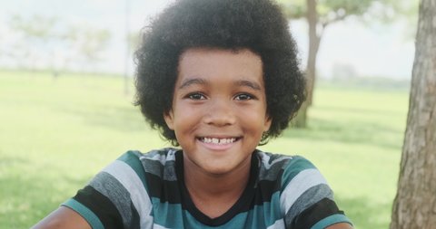 Cute outdoor portrait of a smiling African American young boy.   Video Stok