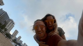Young couple on vacation in Hawaii take cool selfies on famous Waikiki Beach in Honolulu. Couple travelling Hawaii, selfie time. 