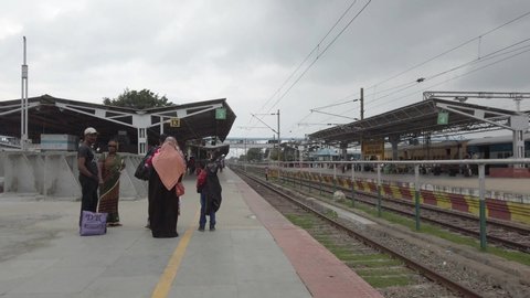 Jolarpettai, Tamilnadu / India - March 17 2020: Wide angle panning shot of a nearly empty railway station due to corona virus threat on an overcast day 