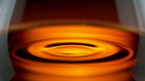Super Slow Motion Detail Shot of Swirling Whiskey in Glass at 1000fps.