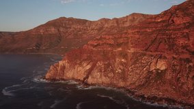 4K high quality aerial sunny afternoon sunset footage of spectacular scenic Chapman's Peak Drive, rocky mountains, Atlantic Ocean between Hout Bay, Noordhoek in Western Cape, Cape Town, South Africa