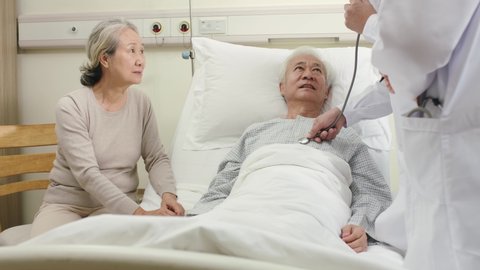 two young asian doctors examining senior patient and informing him of his medical condition