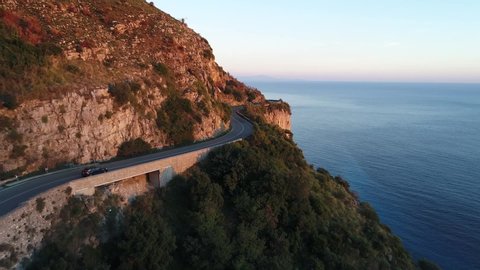 a car is driving in the beautiful amalfi coast in italy during the golden hour