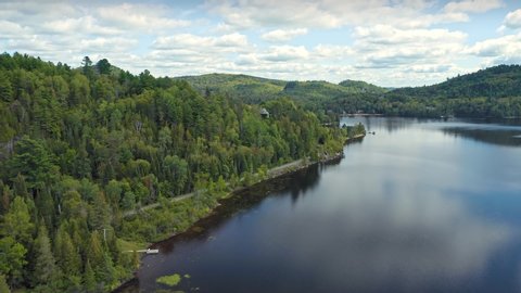 Aerial: Forest & calm tranquil Lac Raymond in the Laurentian Mountains near Montreal, Quebec, Canada 