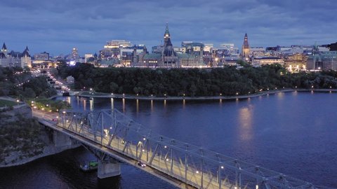 Aerial: Alexandria Bridge crossing the Ottawa River at night. In the background is the Library of Parliament. Ottawa, Ontario, Canada. 11 September 2019 