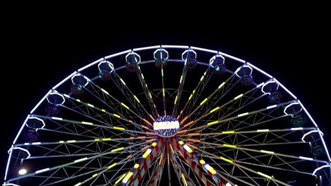 Monaco, Monte Carlo, December 15, 2019: Panoramic wheel at the New Year festive fair in the port of Monaco. Multi-colored light bulbs. Three video plans in one. Christmas. French riviera. Night