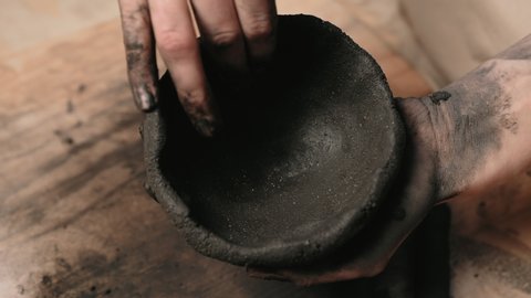 making clay products, ceramics, making ceramics, do-it-yourself creation. woman hands making clay product in motion. Potter's work close-up.Potter rolls clay. Handmade.