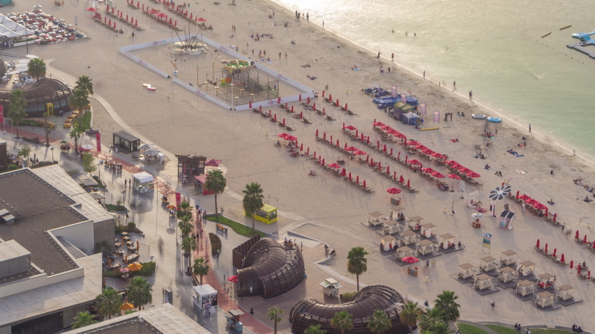 Waterfront overview Jumeirah Beach Residence JBR skyline aerial timelapse with yacht and boats. Shops, restaurants and other entertainment from above