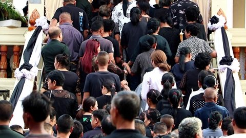 NAKHON NAYOK, THAILAND, SEP 29 2019. A funeral guests walks up the stairs up to the deceased's coffin. Queue of people advancing up to the crematorium.