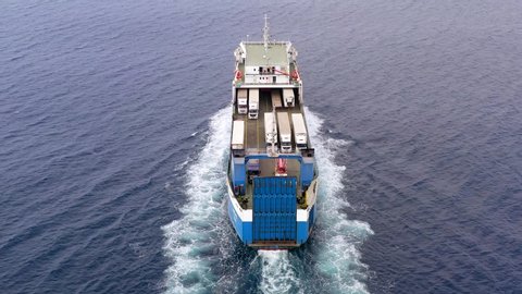 Aerial follow footage of a Large RoRo (Roll on/off) Vehicle carrier vessel cruising the Mediterranean sea.