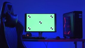 Zoom out of table with futuristic computer, gaming keyboard, mouse and comfortable chair standing nearby illuminated with blue neon light