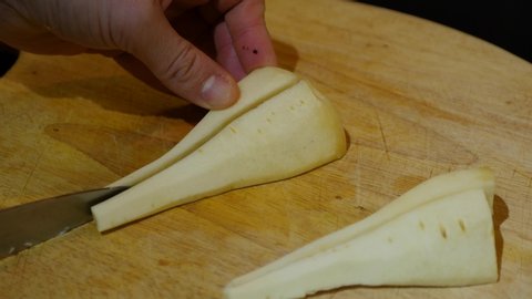 Quartering parsnips on a wooden chopping board