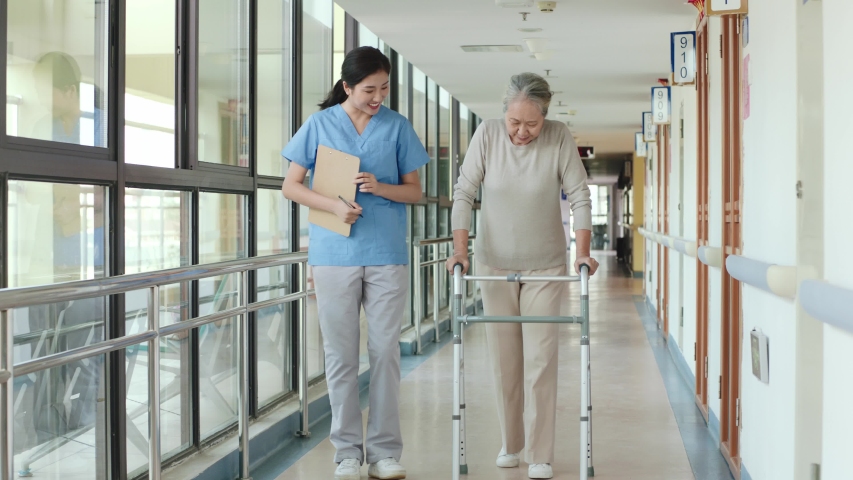 young asian physical therapist working with senior woman on walking using a walker in rehab center or nursing home Royalty-Free Stock Footage #1042933411