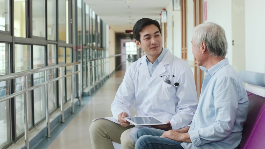 Young asian doctor telling senior couple test result in hospital corridors | Shutterstock HD Video #1042933414