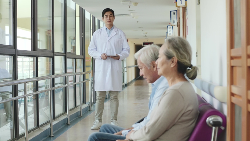 Young asian doctor telling senior couple test result in hospital corridors | Shutterstock HD Video #1042933420
