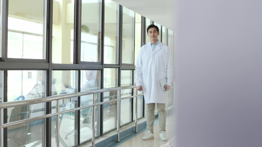 young asian doctor telling mother of child test result in hospital corridors Royalty-Free Stock Footage #1042933423