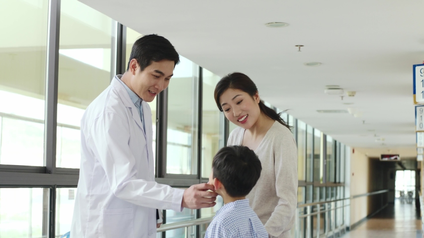 Young asian doctor telling mother of child test result in hospital corridors | Shutterstock HD Video #1042933423