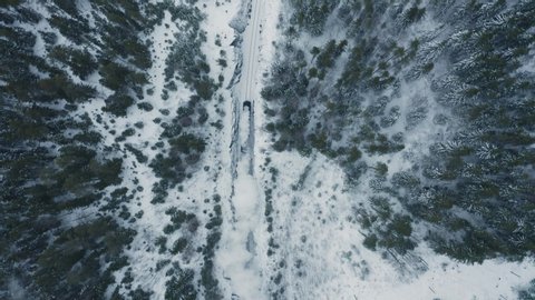 Aerial top view old steam train running in winter snowy forest. Top down view Heritage historic steam locomotive