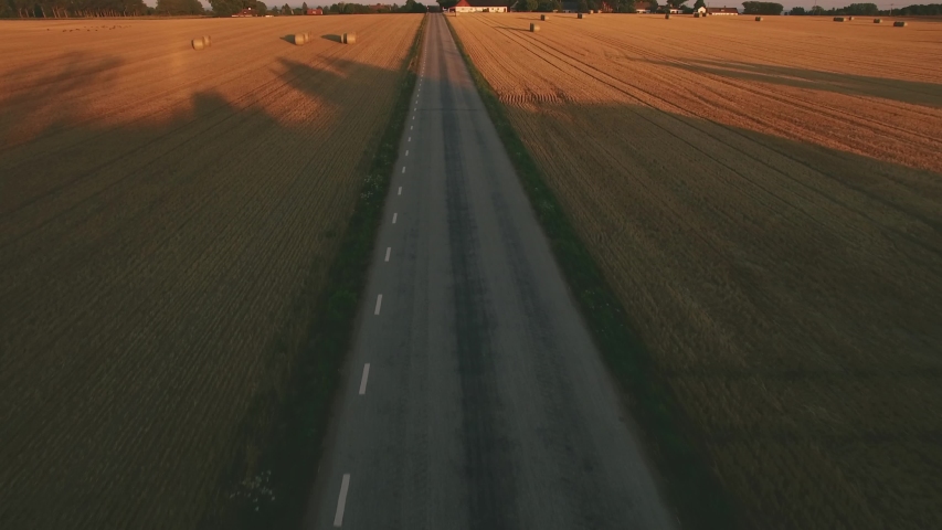 Cycle Aerial. Road cyclist biking in the Swedish countryside in the evening. Location: Skane County, Sweden. August of 2018. 