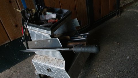 Horse Farrier tools including knife and rasp sit in corner of horse stable barn