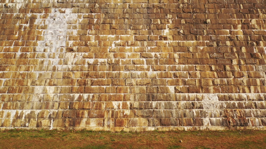 pedestal shot upwards as the drone flies above the dam