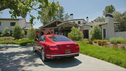 Red Bentley parked by rancho hose, houses in Malibu, shot of real estate exterior, house holding in California: Los Angeles, California / United States - 11 29 2019
