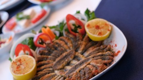 Delicious fried anchovies with lemon slices, Turkish Hamsi Tava