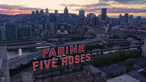 MONTREAL, QUEBEC, CANADA, 1 April 2019: AERIAL: Neon Signage of Farine Five Roses and the Montreal city skyline 