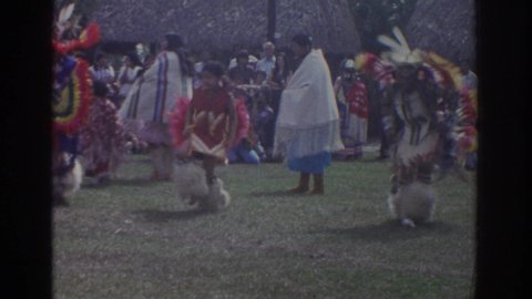 MIAMI FLORIDA USA-1971: Traditional Native Dancing In Ceremonial Feathered Costumes While Crowds Of People Watch