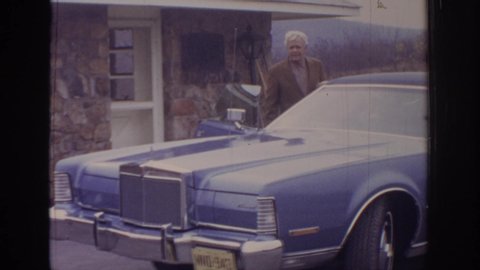 PHILADEPHIA PENNSYLVANIA USA-1972: Super Eight Film Footage Of Man Getting Into Passenger Side Of An Old Blue Car