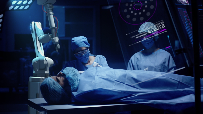 Team of Professional Surgeons perform a Delicate Operation using Medical Surgical Robot while observing Data on Transparent Screens. Modern medical equipment. Robotic arm for minimal invasive surgery. Royalty-Free Stock Footage #1042976131