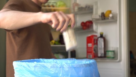 A man throw away spoiled produce from the refrigerator. Reducing Wasted Food At Home Concept