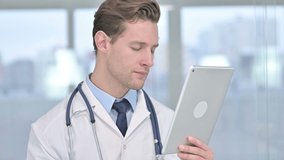 Portrait of Cheerful Young Male Doctor doing Video Chat on Tablet