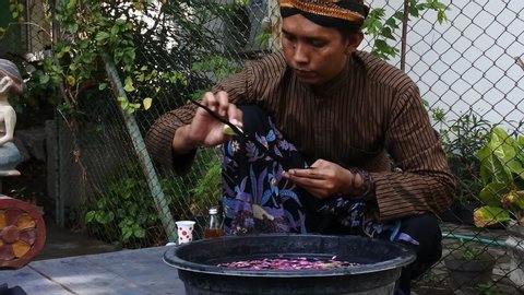 Blora, CENTRAL JAVA / INDONESIA - DECEMBER 8, 2019: Man dressed in Javanese custom washed a keris in the Jamasan Keris ceremony at the district hall