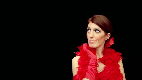 An attractive lady, wearing a red dress and a feather boa, bothered by someone (a bad pickup experience). Front medium shot over a black background, room for copy-space on the left.
