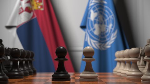 Flags of Serbia and United Nations behind pawns on the chessboard. Conceptual editorial 3D animation