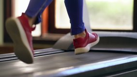 Woman running on a moving treadmill or conveyor belt in a gym during a healthy workout in a fitness and active lifestyle concept