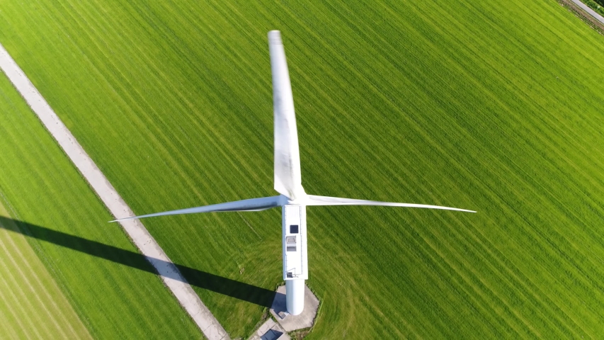 Aerial footage of wind turbine providing sustainable energy by spinning blades the power also known as renewable is collected from resources green field meadow in background 4k high resolution Royalty-Free Stock Footage #1042994104