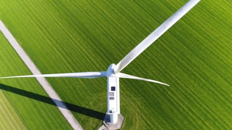 Aerial footage of wind turbine providing sustainable energy by spinning blades the power also known as renewable is collected from resources green field meadow in background 4k high resolution