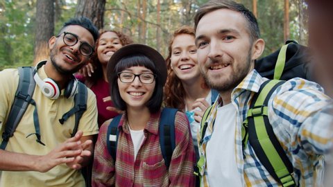 Point of view portrait of joyful young people friends taking selfie travelling in the forest together posing with funny gestures. Youth and self-portrait concept.