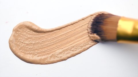 Foundation face make-up smudge, smear. Cosmetic liquid foundation or bb cream beige color smudge, smear, stroke. Make up smears isolated on a white background. Brush. Texture. 4K UHD video