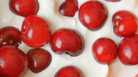 milk yogurt or cream and fresh cherries in bowl rotate, healthy food and drink concept
